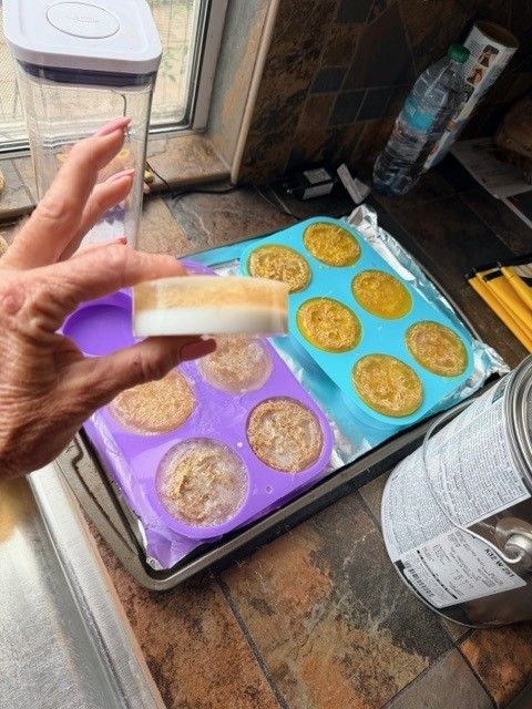 A finished luffa soap bar held above the molds