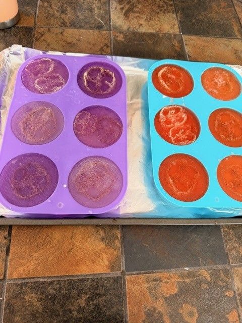 Purple and orange luffa soap bars setting in silicone molds
